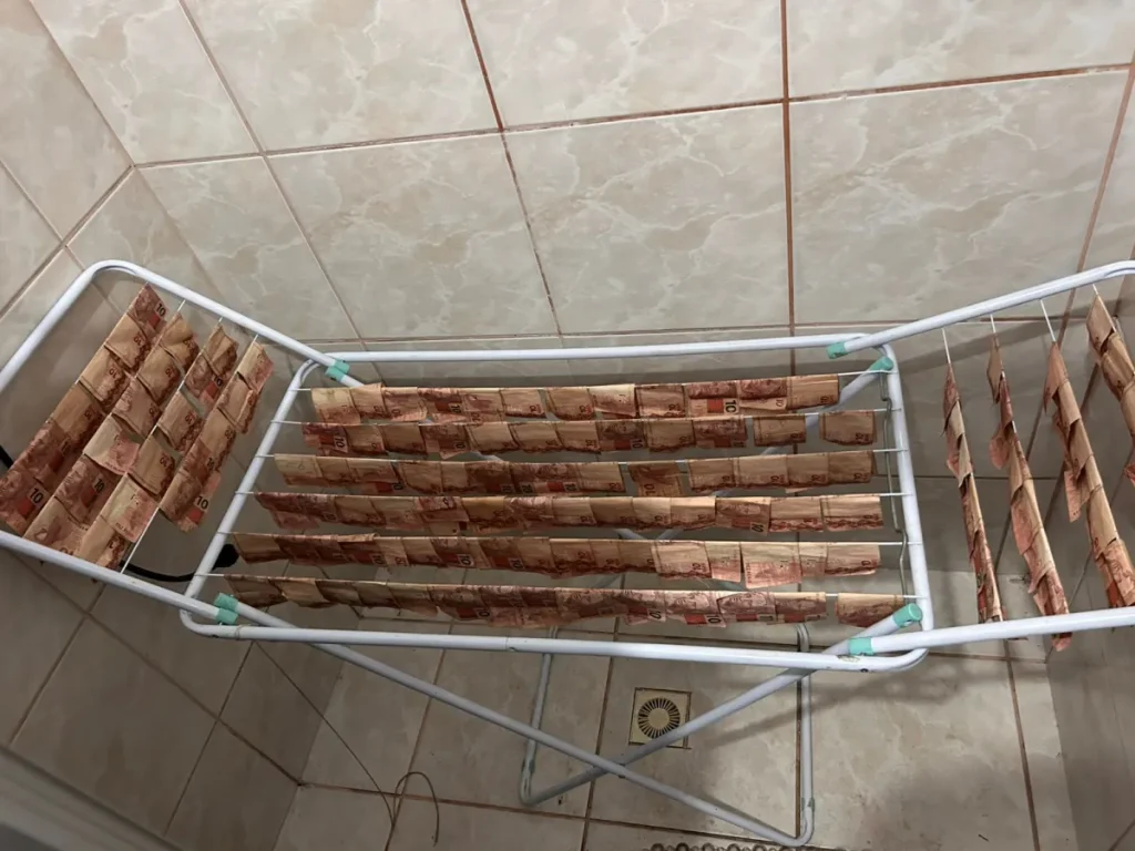 Dinheiro no varal: polícia encontra pilhas de notas “secando” e em mala